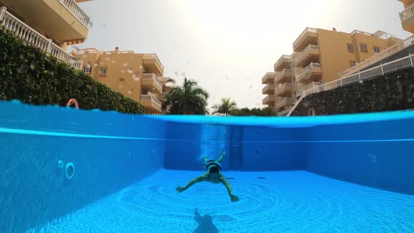 Young teen boy have fun swimming underwater at the pool in summer active holiday vacation