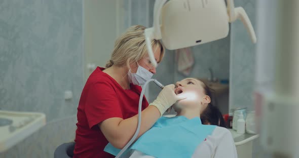 Young Girl at the Reception at the Dentist Sitting in a Chair with an Open Mouth