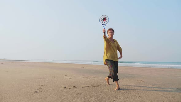 Senior Woman Practicing Tai Chi Balloon Ball on the Beach