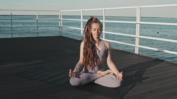 Woman Meditating on Pier