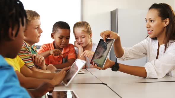 Teacher Teaching Kid on Digital Tablet in Library