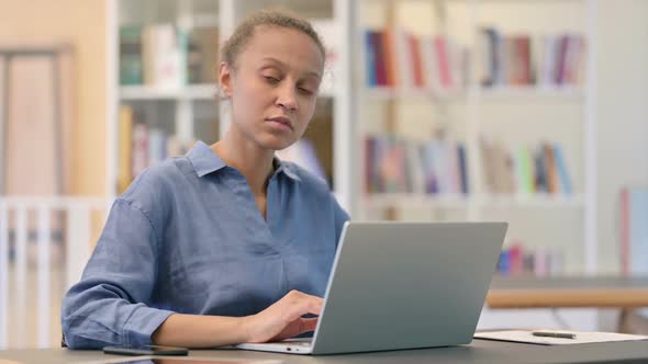 Young African Man with Laptop Doing Thumbs Down