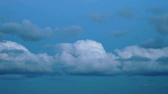 Group of Fluffy Clouds Float Fast Across Blue Sky Timelapse