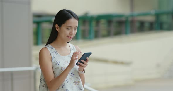 Woman use of mobile phone out of the station