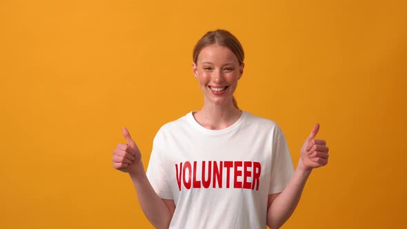 Smiling woman volunteer showing thumb up at the camera