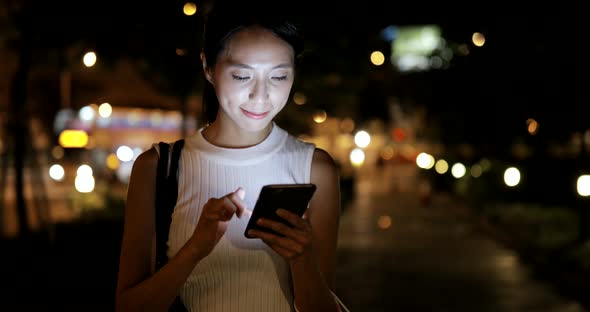 Woman using mobile phone in city 