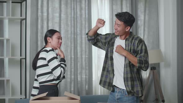 Happy Young Asian Couple Celebrating Finish Carrying Cardboard Boxes With Stuff Into A New House