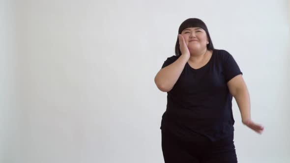 Energetic Asian Girl Happy Fatty Dancing Slow Motion on a White Background.