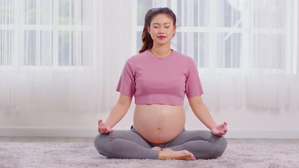 Happy Calm Pregnant Woman deep breath with fresh air do yoga lotus pose comfortable at home