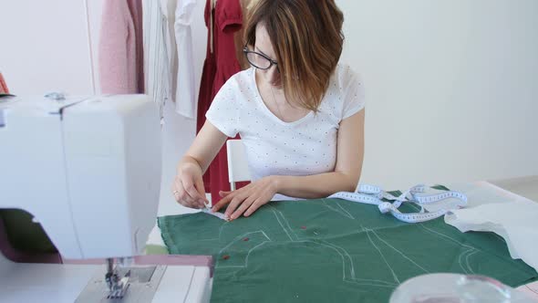 Concept of Hobby and Small Business. Young Female Designer Is Designing Clothes in a Bright Studio
