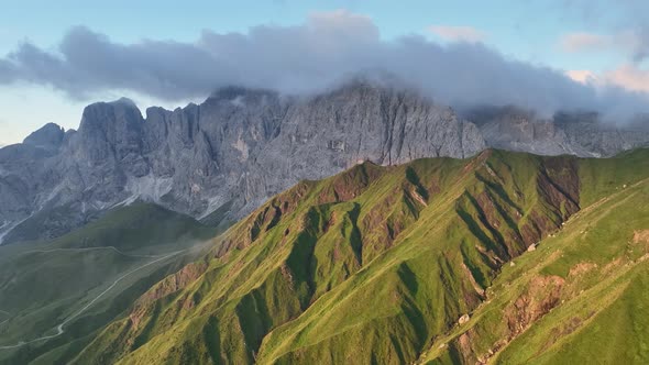 Dolomites mountains peaks with a hiking path on a summer sunrise