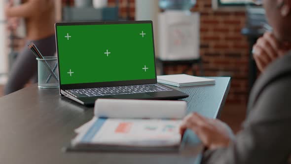 Man Using Greenscreen on Laptop and Taking Notes