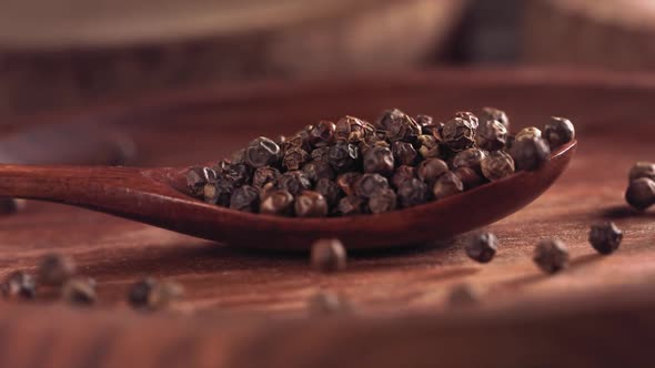 Black Pepper Falling on a Wooden Spoon