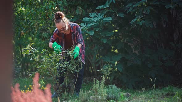 Happy Beautiful Mature Woman in Gardening Gloves Works in the Garden