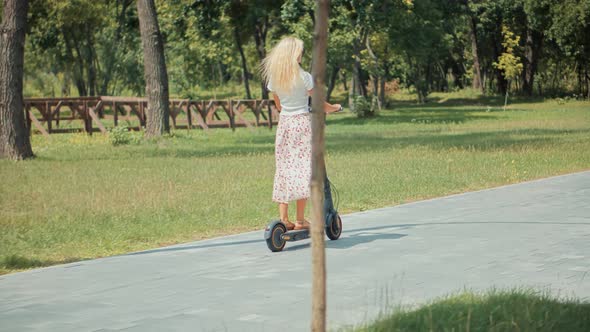 Renewable Energy Transport. Alternative Transportation In City. Woman Taking Electronic Scooter.