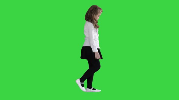 Little Girl with Long Hair Walking and Looking Down on a Green Screen