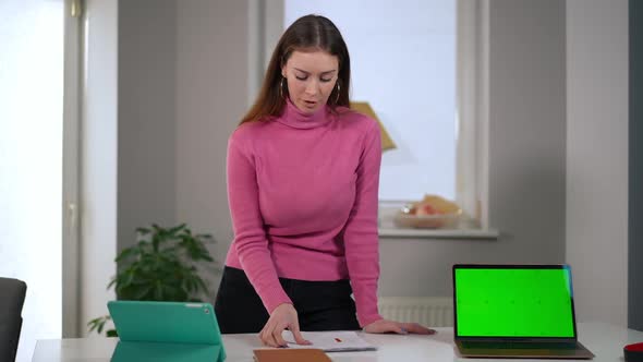 Portrait of Unsatisfied Young Caucasian Woman Looking at Camera Talking with Green Screen Laptop on