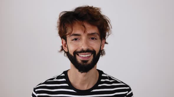 Cheerful Young Adult Hipster Man Smiling at Camera Against White Background