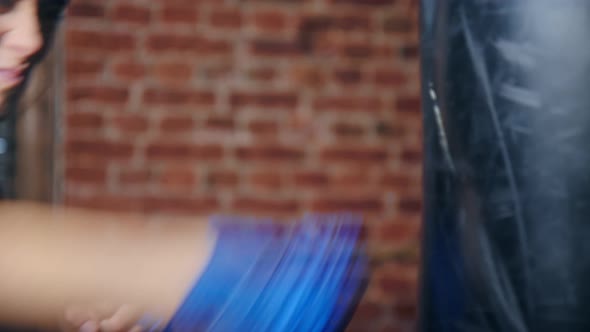 Closeup Female Blue Wrapped Hand Hitting Punching Bag Enjoying Kickboxing Training at Loft Gym