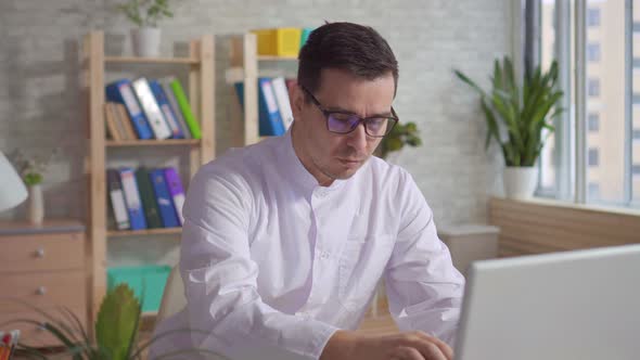 Male Doctor in White Coat Working in Clinic