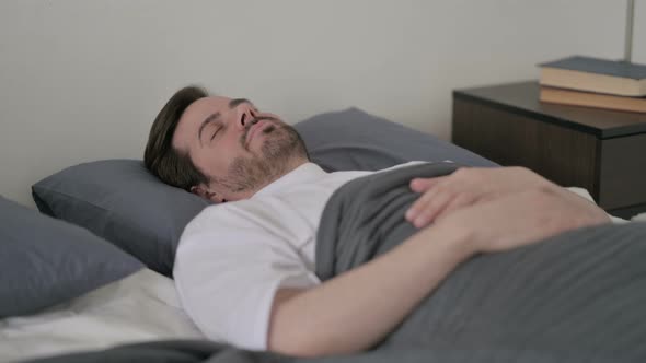 Young Man Sleeping in Bed Peacefully