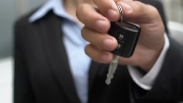 Male Hand Giving Car Keys to Cheerful Business Woman, Automobile Purchase, Joy