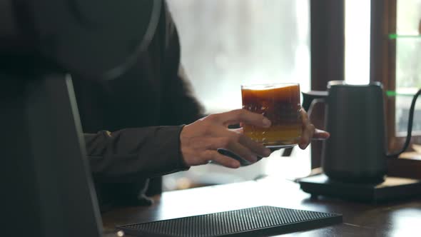 4K Asian woman barista making iced black coffee with orange juice serving to customer