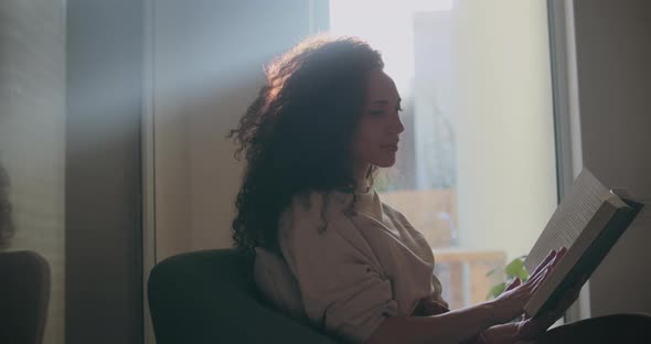 Light shining on a women reading a book