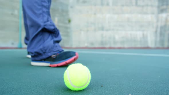 Man picking up tennis ball