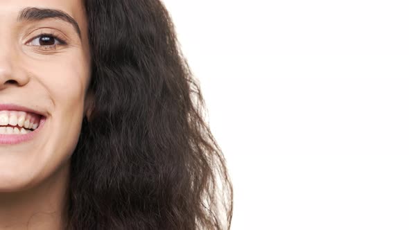 Extreme Closeup Halfside Portrait of Content Caucasian Lady with Dark Curly Hair Posing with Smiling