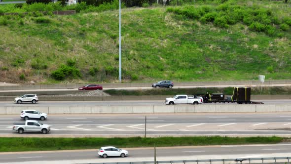 Traffic and busy highway scene. Cars and trucks vehicles on expressway. Tight aerial zoom in view.