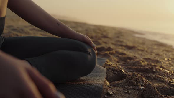 Woman Body Sitting Lotus Pose on Sand Beach Close Up