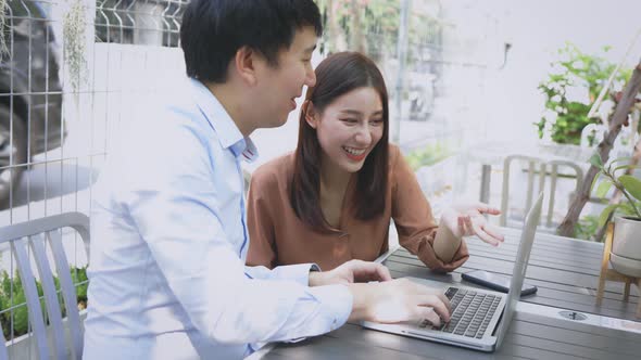 Man and Woman Using Laptop in Cafe