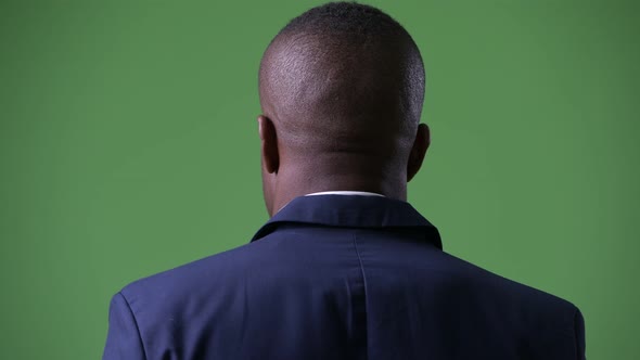 Rear View of Young African Businessman Looking Back