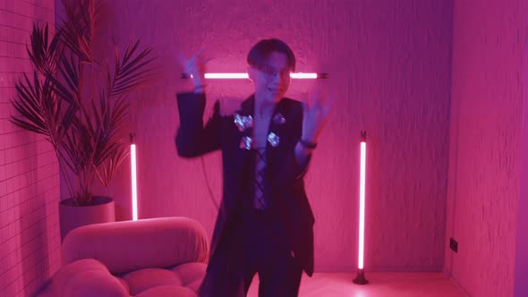 Teenage Guy Dancing in Pink Lights