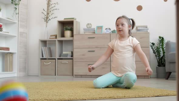 Cheerful Handicapped Girl Playing with Ball in Living Room