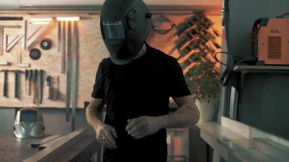 Welding engineer puts on a welding mask and prepares the workplace for the start of welding work