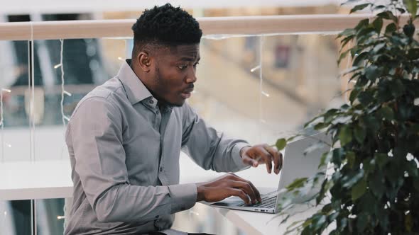 Shocked Young Businessman Working on Laptop Feeling Frustrated Stressed By Problem Despair