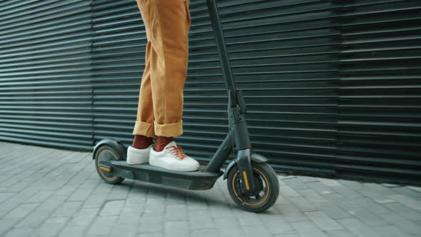 Low Section of Man Riding Electric Scooter