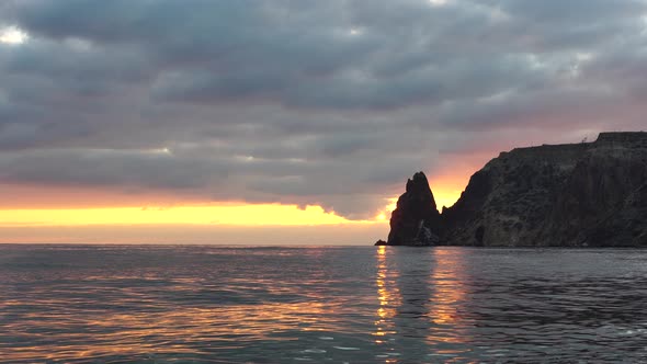 Colorful Warm Sunset Over the Sea and Volcanic Basalt Rocks Like in Iceland