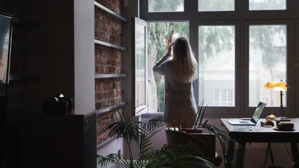 Caucasian woman using her phone in her house