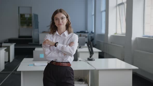 Pretty Young Girl Smiles on the Camera in an Office