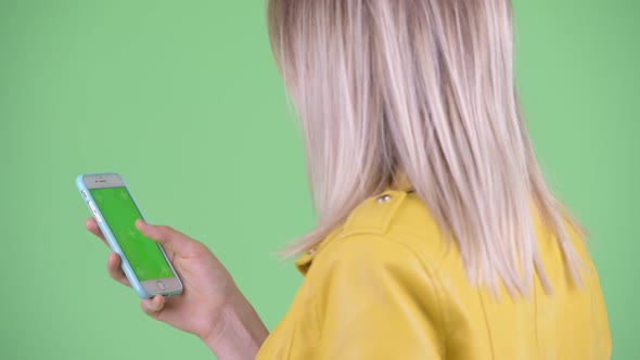 Closeup Rear View of Young Rebellious Blonde Woman Using Phone