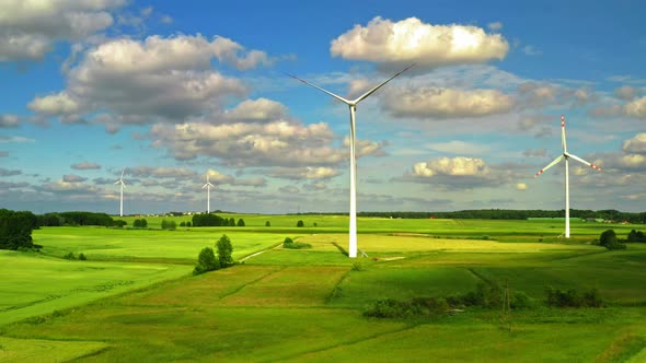 Aerial view of wind turbines with blue sky on green field , Poland