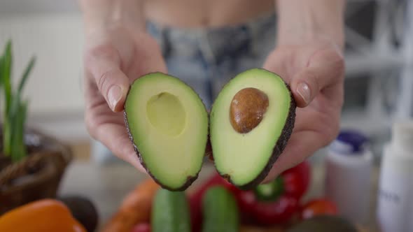 Closeup Female Hands Opening Green Avocado