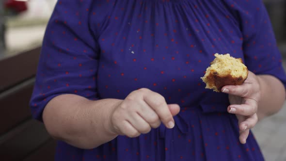 Fat Woman Eating Bun at the Street