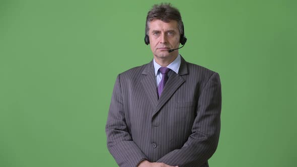 Mature Handsome Businessman Against Green Background