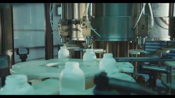 Conveyor At The Enterprise For Dividing Liquids Into White Plastic Bottles