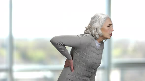 Old Thin Woman Suffering From a Back Pain