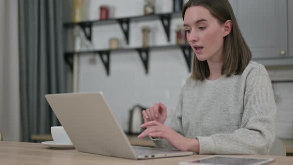 Excited Young Woman Celebrating Success on Laptop at Home 